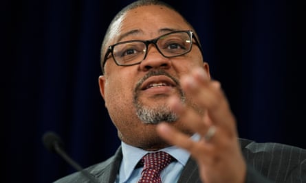 Larger Black man with bald head and salt-and-pepper goatee in suit speaks and gestures with left hand.