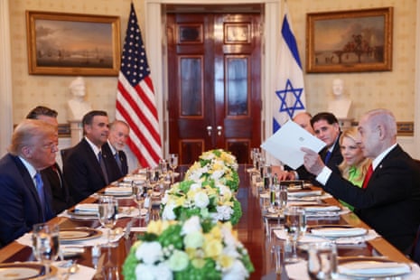 Israeli Prime Minister Benjamin Netanyahu hands over a document to U.S. President Donald Trump during a bilateral dinner, at the White House in Washington, D.C., U.S., July 7, 2025. REUTERS/Kevin Lamarque