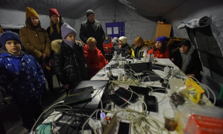 Les gens rechargent leurs appareils à un point de chauffage organisé par les services d'urgence de l'État lors d'une coupure de courant à Kyiv le 24 novembre.