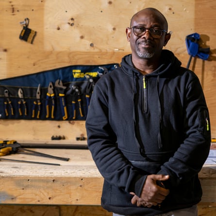John Mava in front of a wooden workbench