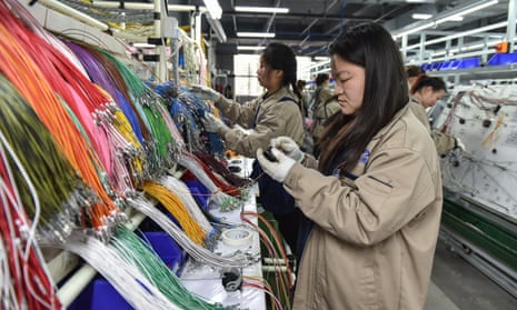 Employees work on a wire harness production line at a factory which supplies car accessories to the automotive market in Fuyang, in eastern China's Anhui province on 28 March 2024.