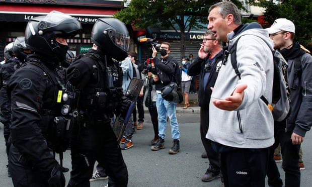 A demonstrator argues with police at an anti-Covid rules protest in Paris