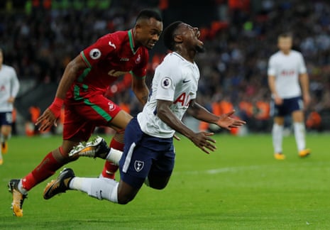 Tottenham’s Serge Aurier goes down under a challenge from Swansea City’s Jordan Ayew.