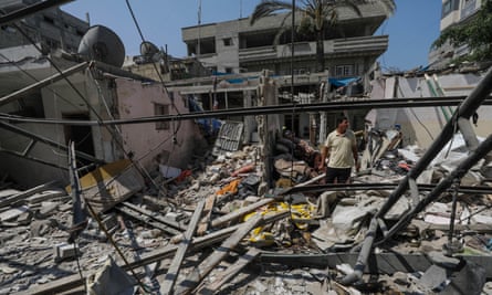 A man walks among the rubble of a destroyed house