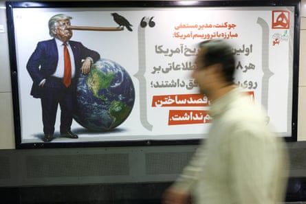 People walk past a caricature depicting Donald Trump, in Tehran, Iran.