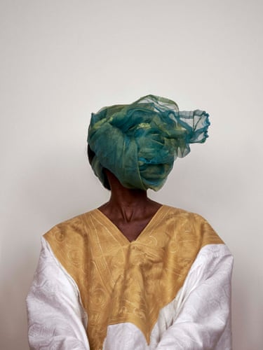 Worn white grand-bubu with gold embroidery and green headscarf, Grey Area, 2022The embroidered grand boubou gives the body presence, dignity and authority, while the headscarf removes the face from view.Drawing on the fluidity of agarment worn across genders, the image shifts attention from identity to the codes through which appearance is constructed.Beauty becomes both an opening and a screen, capable of carrying silence, avoidance and concealed violence.