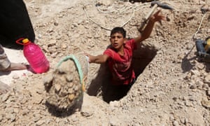 A young boy digs a grave.
