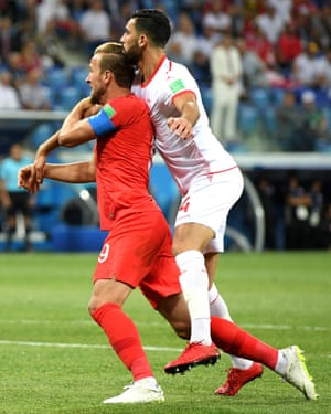 Harry Kane of England and Yassine Meriah of Tunisia clash in the penalty area.