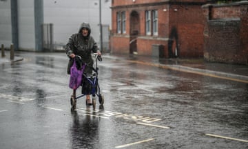 A woman walks in heavy rain in Stoke on Trent