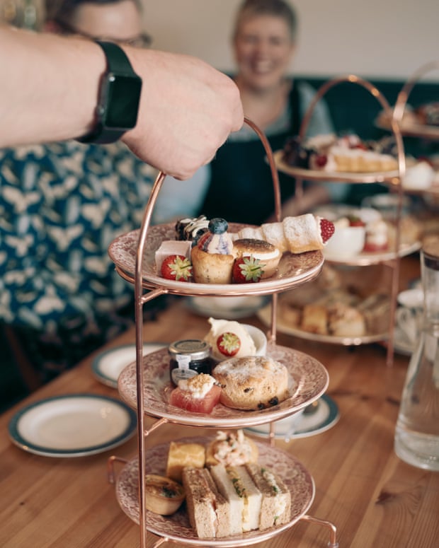 A cake stand laden with cakes and sandwiches