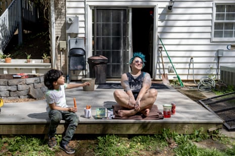 A woman and her son sit on a deck smiling