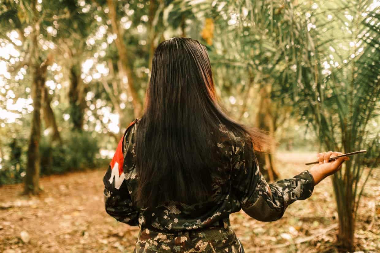 A fighter with her back to the camera combing her hair