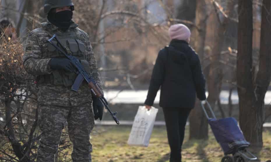 armed soldier and woman with wheeled shopping bag