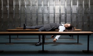 A young girl asleep on a bench in a locker room