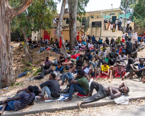 Migrants rest outside the Temporary Center for Immigrants (CETI) after crossing from Morocco into the Spanish enclave of Ceuta, Friday.