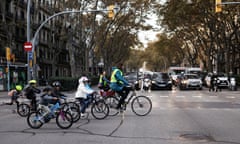 Children and parent volunteers ride their bicycles to school on car-free streets in Barcelona, Spain
