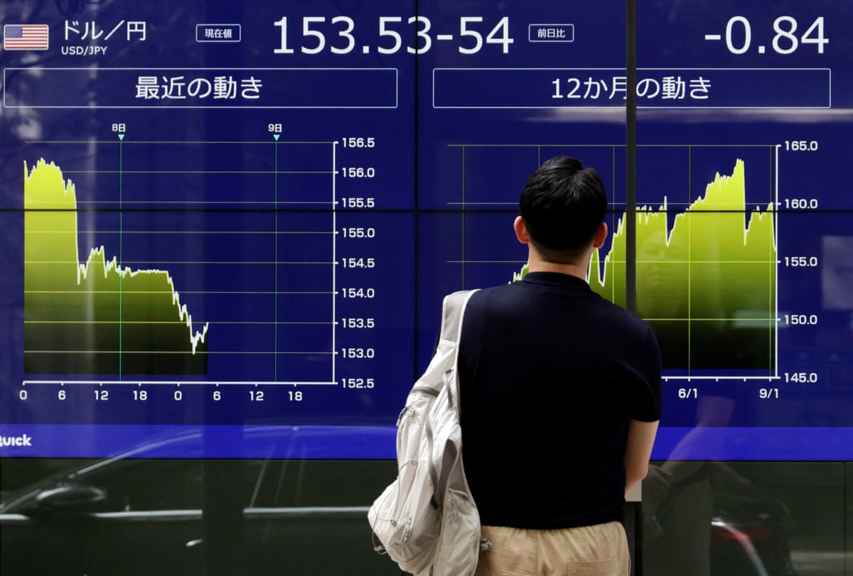 A passerby looks at a large screen of currency rates.