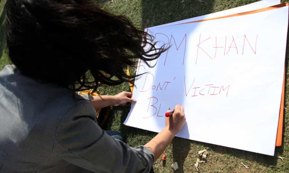 An activist of Pakistani rights groups prepares a placard during a protest against Prime Minister Imran Khan’s remarks on the reasons of rising in rape cases