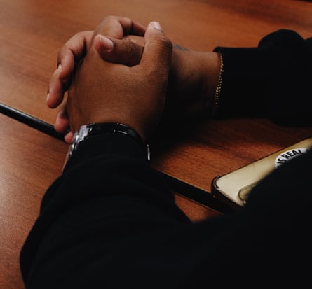 close up image of hands rested in a calm manner on a wooden table