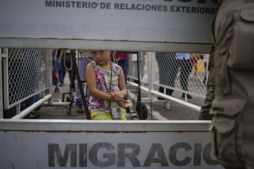 child seen through barrier that says 'migracion'