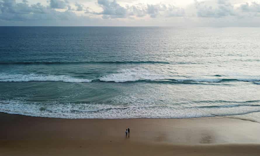 Menschen gehen an einem leeren Strand entlang, während sich Phuket darauf vorbereitet, sich für ausländische Touristen zu öffnen.