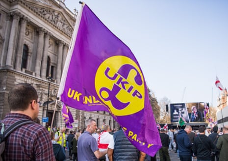 A Leave supporter carries a UKIP flag in Whitehall Pro and anti Brexit protests in 2019