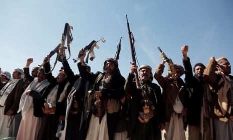 Houthi followers raise their weapons in the air at a tribal rally
