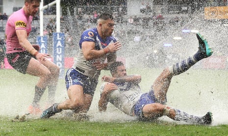 Nick Cotric and Corey Allan of the Bulldogs dive for the ball in the wet at Bankwest Stadium