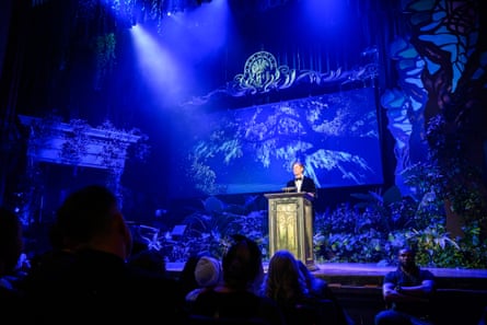 a man in a suit speaks into a microphone