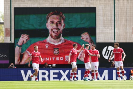 Wrexham celebrate in front of the big screen showing Sam Smith after he put them 2-1 ahead