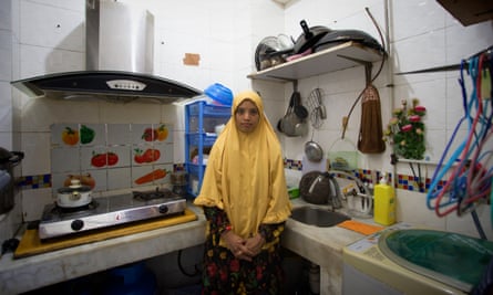 Ratna Khaleesy, migrant worker, stands in kitchen at home shared by 11 others, Macau