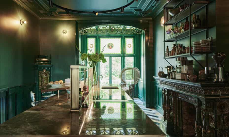 Rich greens, stained glass and floor-to-ceiling windows in the kitchen, which features 30 different types of marble and an onyx worktop.
