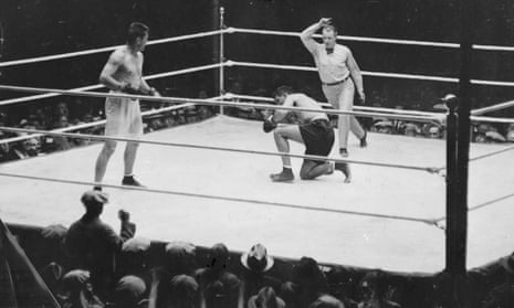 Gene Tunney (L) looks on after he knocks down Jack Dempsey during the fight in Chicago on 22 September 1927. Gene Tunney won the contest.