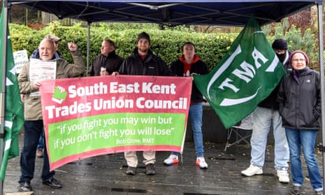 Rail workers hold banners during a strike over pay outside Ashford international station in Kent.