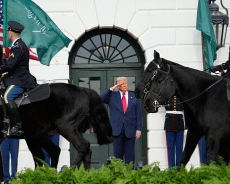 Donald Trump salutes as he waits for the arrival of Mohammed bin Salman.