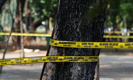 Police tape around a tree covered area