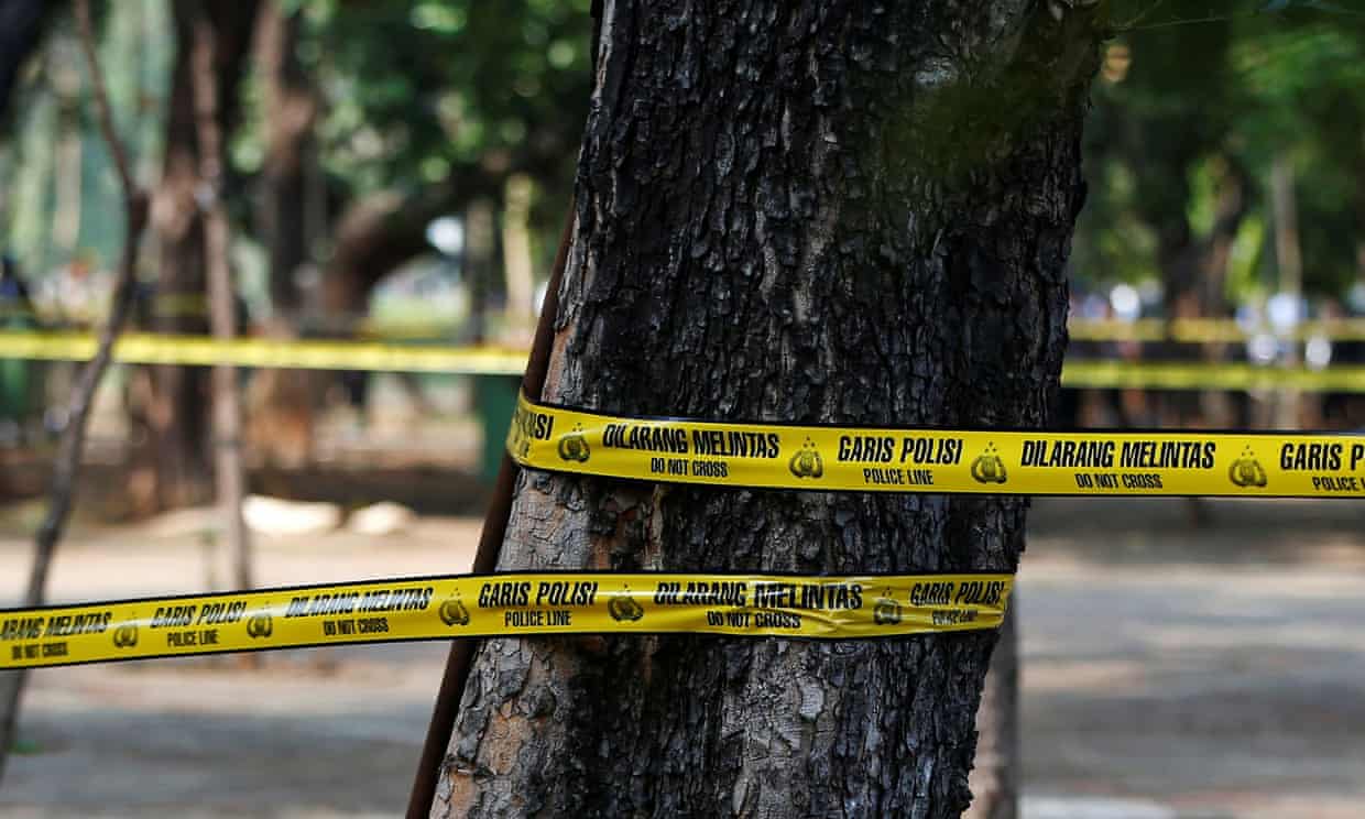 Police tape around a tree covered area