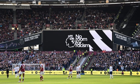 Long shot of the big multi-deck Trevor Brooking stand full of people, with a large 'No Room for Racism banner' showing on the electronic video screen mounted between the bottom two tiers