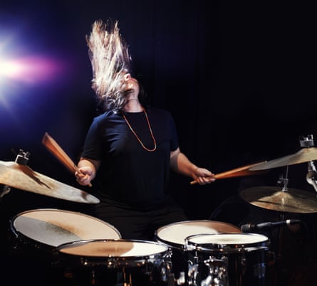 Shot of a young woman rocking out on a drum kit