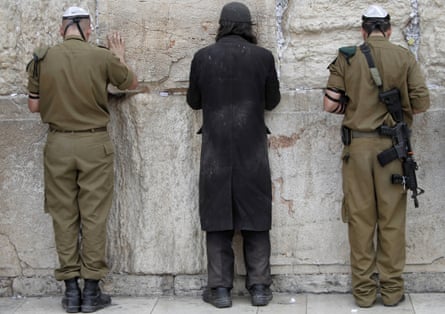 Israeli soldiers and an ultra-Orthodox Jewish man pray at the Western Wall, in Jerusalem’s Old City.