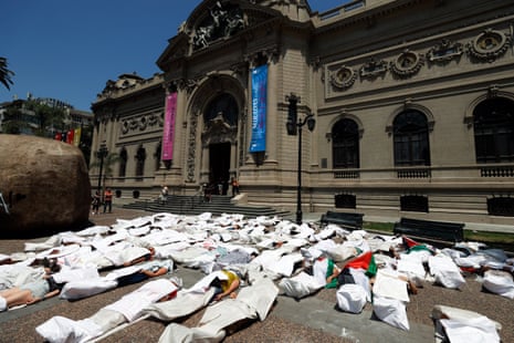 Demonstrators lie down covered in white sheets and Palestinian flags during a symbolic demonstration in support of the Palestinian people, marking 90 days of Israel’s war on Gaza, in front of the National Museum of Fine Arts building in Santiago, Chile, 06 January 2024.
