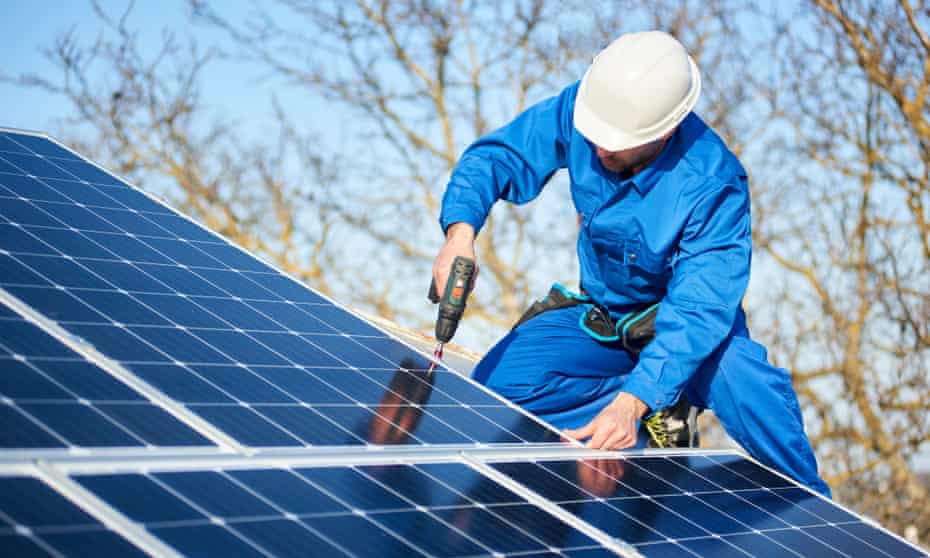 A workman installing a solar panel