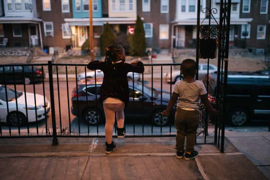 Cissy, four, left, and Aly, two, wait for their dad at their home in Philadelphia. Both were found to have lead poisoning from paint.