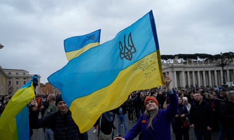 People wave Ukrainian flags in St Peter’s Square outside the pope’s window