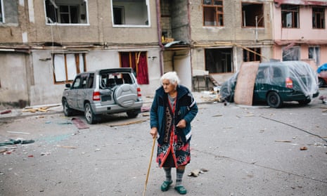 An elderly woman leaves her apartment during a lull in shelling in Stebanakert.