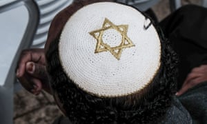 white star-of-david kippah (skullcap) on the head of a black man