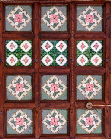 Twelve tiles with pink flower designs inlaid in a dark wood surround