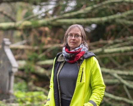 Juliet Line stands in front of felled trees in a churchyard