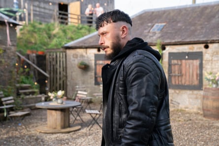 A man with a dark jacket stares intensely at someone off camera.