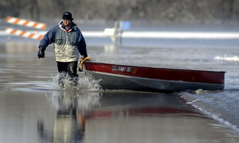 Jared Bakko hauls a boat down a flooded road after taking supplies to his grandmother as the Red River flood waters began to recede just south of Moorhead, Minnesota, USA, 28 March, 2009. EPA/CRAIG LASSIG
